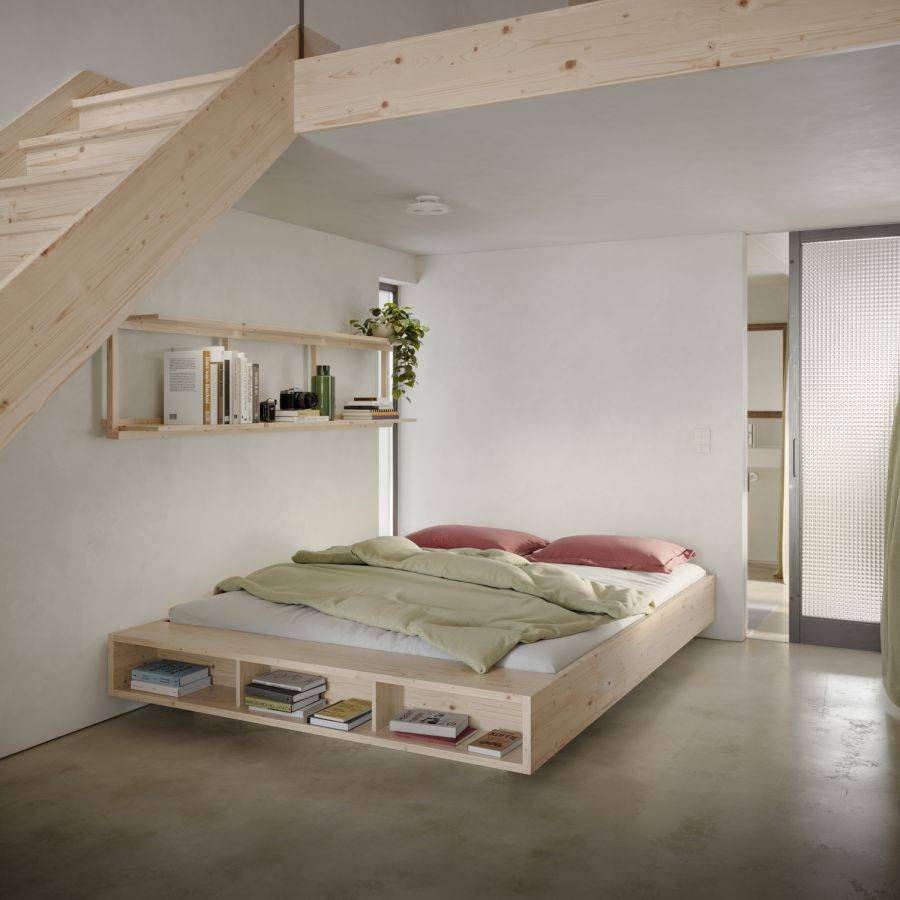 Karup futonbed Merge van FSC-gecertificeerd dennenhout; laag ‘zwevend’ frame met drie open vakken vol boeken in een minimalistische loft (140 × 200 cm).